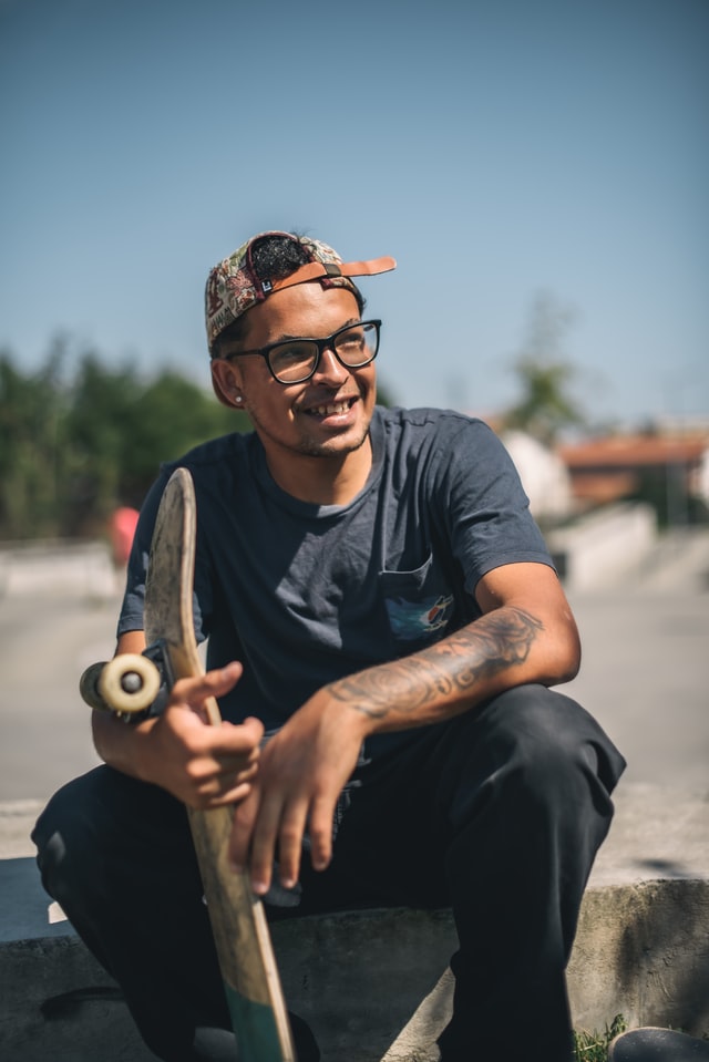 man sitting down with skateboard
